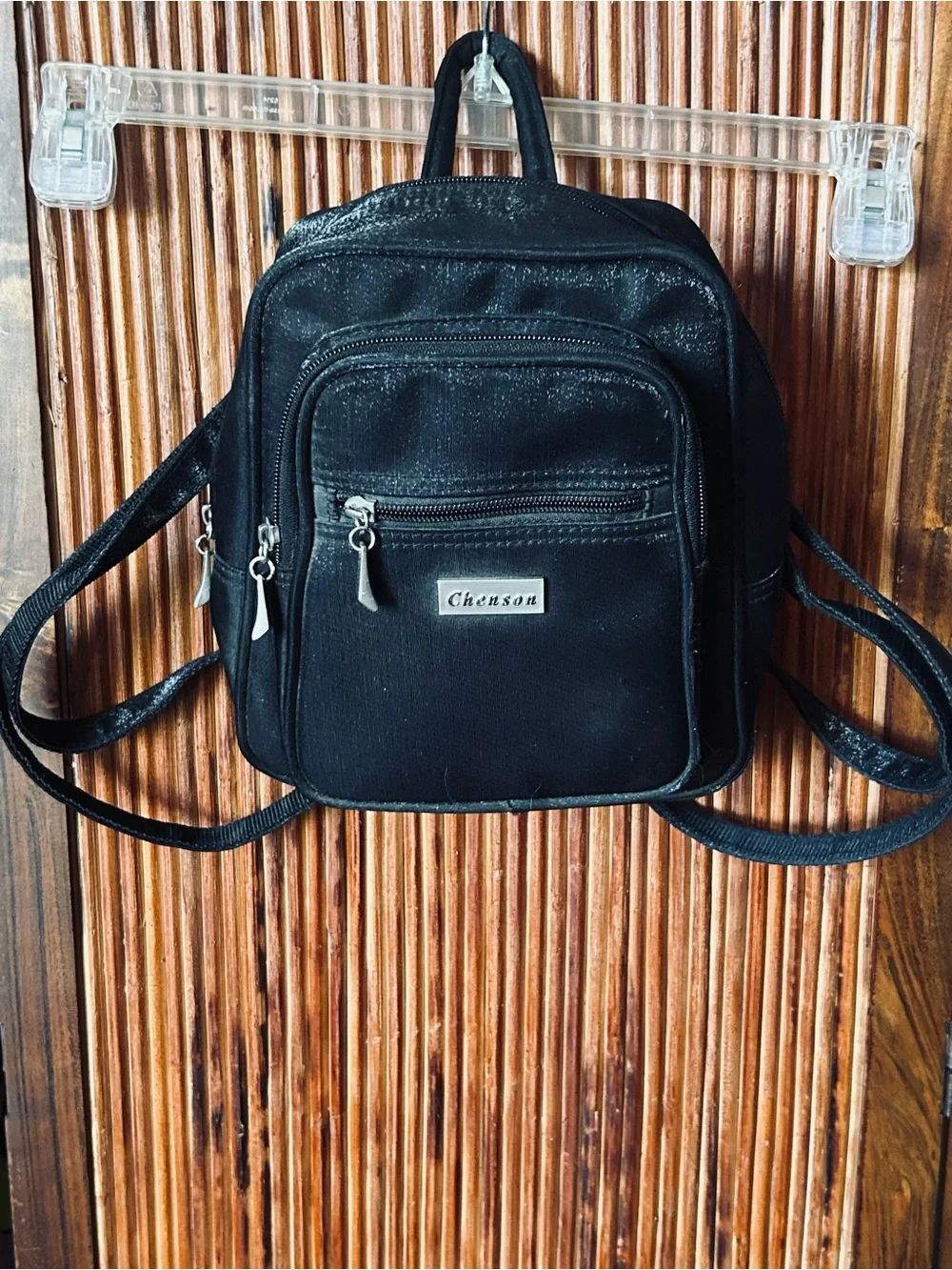 Backpack mini style. Black little purse with lots of compartments and zippers.